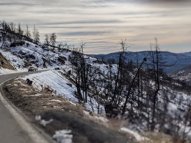 road leading down from mountain. Snow plowed to both sides.